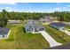Charming single-story home with a well-manicured lawn and long driveway, surrounded by lush greenery at 6765 152Nd Lane Rd, Ocala, FL 34473