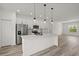 Modern kitchen with stainless steel appliances, a large island, and pendant lighting at 6765 152Nd Lane Rd, Ocala, FL 34473