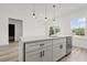 Kitchen featuring a large island with seating, modern cabinets, a black faucet, and stainless steel dishwasher at 6765 152Nd Lane Rd, Ocala, FL 34473