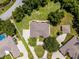 Aerial view of home with mature trees, circular driveway, and screened-in lanai at 707 Heritage Ne Dr, Winter Haven, FL 33881