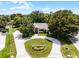 A bird's-eye view of a home with lush landscaping and a circular driveway surrounded by mature trees at 707 Heritage Ne Dr, Winter Haven, FL 33881