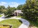 Charming single-story home with a circular driveway, lush landscaping, and mature trees at 707 Heritage Ne Dr, Winter Haven, FL 33881