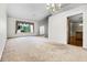 Spacious living area with carpet floors, large windows, and double doors to the foyer at 707 Heritage Ne Dr, Winter Haven, FL 33881