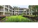 Well-maintained condo courtyard features manicured green lawn, colorful flowers, and lush landscaping at 7220 Westpointe Blvd # 1429, Orlando, FL 32835