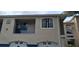 Exterior view of condo building showing tan stucco with blue accents, garage doors, and private balcony at 7220 Westpointe Blvd # 1429, Orlando, FL 32835