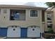 Exterior view of condo building showing tan stucco with blue accents, garage doors, and private balcony at 7220 Westpointe Blvd # 1429, Orlando, FL 32835