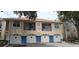 Charming condo building exterior with tan stucco, blue accents, and private balconies over garages at 7220 Westpointe Blvd # 1429, Orlando, FL 32835