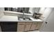 Well-lit kitchen features stainless steel double sink, black dishwasher, light wood cabinets, and white countertops at 7220 Westpointe Blvd # 1429, Orlando, FL 32835
