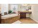 Luxurious bathroom with a corner tub, tile surround, and vanity with granite countertop at 7409 Fairgrove Ave, Windermere, FL 34786