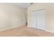 Clean, neutral bedroom with double closet doors and carpet flooring, offers a serene and minimalist aesthetic at 7409 Fairgrove Ave, Windermere, FL 34786