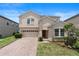 Charming two-story home featuring a brick driveway, well-manicured landscaping, and a neutral color scheme at 7409 Fairgrove Ave, Windermere, FL 34786