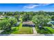 Aerial view of charming home with blue exterior, lush landscaping, and bright red front door at 91 High St, Winter Haven, FL 33880