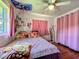 Cute bedroom with laminate floors, pink accents, and overhead ceiling fan at 91 High St, Winter Haven, FL 33880