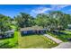 Charming blue home featuring a lush green lawn, mature trees, and a welcoming red front door at 91 High St, Winter Haven, FL 33880