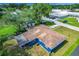 Aerial view of a quaint blue home with a screened porch and adjacent Lawton Baptist Church at 91 High St, Winter Haven, FL 33880