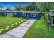 Quaint blue home featuring a green lawn, charming walkway, and an inviting red front door at 91 High St, Winter Haven, FL 33880