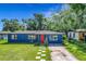 Charming blue home with a well-manicured lawn and a striking red front door, creating a welcoming curb appeal at 91 High St, Winter Haven, FL 33880