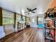 Bright office area with wood-look floors, lots of windows, ceiling fan, and adjacent shelving at 91 High St, Winter Haven, FL 33880