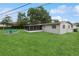 Manicured backyard with green grass and a view of the screened-in patio and backyard patio seating area at 941 Grey Oak Ct, Orlando, FL 32809