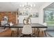 Bright dining room featuring a modern light fixture, a brick wall, and views through a sliding glass door at 941 Grey Oak Ct, Orlando, FL 32809