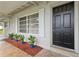 Inviting front door enhanced by potted plants, trimmed mulch, and an adjacent window with crisp white shutters at 941 Grey Oak Ct, Orlando, FL 32809