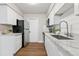Kitchen featuring white cabinets, marble countertops, stainless steel appliances, and wood-look flooring at 941 Grey Oak Ct, Orlando, FL 32809