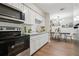 Kitchen with white cabinets and marble countertops that opens into an adjacent dining area at 941 Grey Oak Ct, Orlando, FL 32809