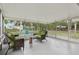Enclosed patio featuring wicker chair and sofa seating area, plus a view to the backyard and patio seating area at 941 Grey Oak Ct, Orlando, FL 32809