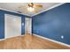 Bright bedroom with blue walls, featuring wood floors and a double closet at 4318 Waterfront Pkwy, Orlando, FL 32806