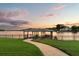 Private boat dock and covered seating area with tranquil sunset views over the serene lake at 4318 Waterfront Pkwy, Orlando, FL 32806