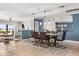 Open concept dining area boasts modern lighting, large mirror, neutral rug, and stylish blue accent wall at 4318 Waterfront Pkwy, Orlando, FL 32806