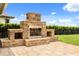 Stone outdoor fireplace featuring built-in storage and a spacious patio area for entertaining at 4318 Waterfront Pkwy, Orlando, FL 32806