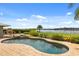 Inviting outdoor pool with stone patio and lovely landscaping overlooking the serene lake view at 4318 Waterfront Pkwy, Orlando, FL 32806