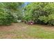 Large tree-filled backyard featuring a pink play house at 1066 Swanson Dr, Deltona, FL 32738