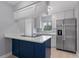 Bright kitchen with stainless steel appliances, white cabinetry, and an island with cooktop at 1066 Swanson Dr, Deltona, FL 32738