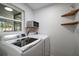 Well-lit laundry room with front loading washer and dryer and built-in storage shelves at 116 E Lauren Ct, Fern Park, FL 32730