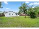 Lush backyard with green grass, mature trees, and a white home exterior at 1161 Roxboro Rd, Longwood, FL 32750