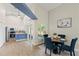 Dining area features a round glass table, vaulted ceilings, and seamless flow into kitchen with blue paneled island at 1161 Roxboro Rd, Longwood, FL 32750