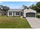 Charming single-Gathering home with well-maintained lawn, gray roof, driveway and two-car garage at 1161 Roxboro Rd, Longwood, FL 32750