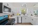 Bright kitchen featuring white cabinets, stainless steel appliances, and a bright teal stove and oven at 1161 Roxboro Rd, Longwood, FL 32750