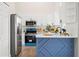 Clean kitchen boasts white cabinetry, stainless steel appliances, and a blue paneled island, blending style and functionality at 1161 Roxboro Rd, Longwood, FL 32750