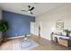 Bright living room with hardwood floors, blue accent wall, modern ceiling fan and stylish furnishings at 1161 Roxboro Rd, Longwood, FL 32750