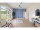 Bright living room with hardwood floors, blue accent wall, large window, ceiling fan, and stylish decor at 1161 Roxboro Rd, Longwood, FL 32750