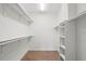 Empty walk-in closet featuring custom shelving and wood floor at 1161 Roxboro Rd, Longwood, FL 32750