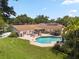Charming backyard featuring a refreshing pool, lush landscaping, and outdoor dining and lounge areas at 1191 Banbury Trl, Maitland, FL 32751