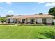 Charming single-story home featuring a lush front lawn, inviting porch with seating, and manicured landscaping at 1191 Banbury Trl, Maitland, FL 32751