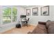 Bright home office features a modern desk, dual monitors, and stylish decor with a comfortable brown leather couch at 1191 Banbury Trl, Maitland, FL 32751