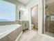 Well-lit bathroom with a soaking tub and a glass-enclosed shower at 12795 Bosworth Ave, Windermere, FL 34786