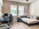 Bright bedroom featuring two windows, laminate floors, a work desk, and a comfortable bed at 12795 Bosworth Ave, Windermere, FL 34786