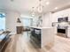 Modern kitchen featuring a large island, stainless steel appliances, and stylish pendant lighting at 12795 Bosworth Ave, Windermere, FL 34786